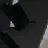 Close-up detail shot of a matte black plastic component, showing a curved mounting bracket or clip with a small circular screw detail.