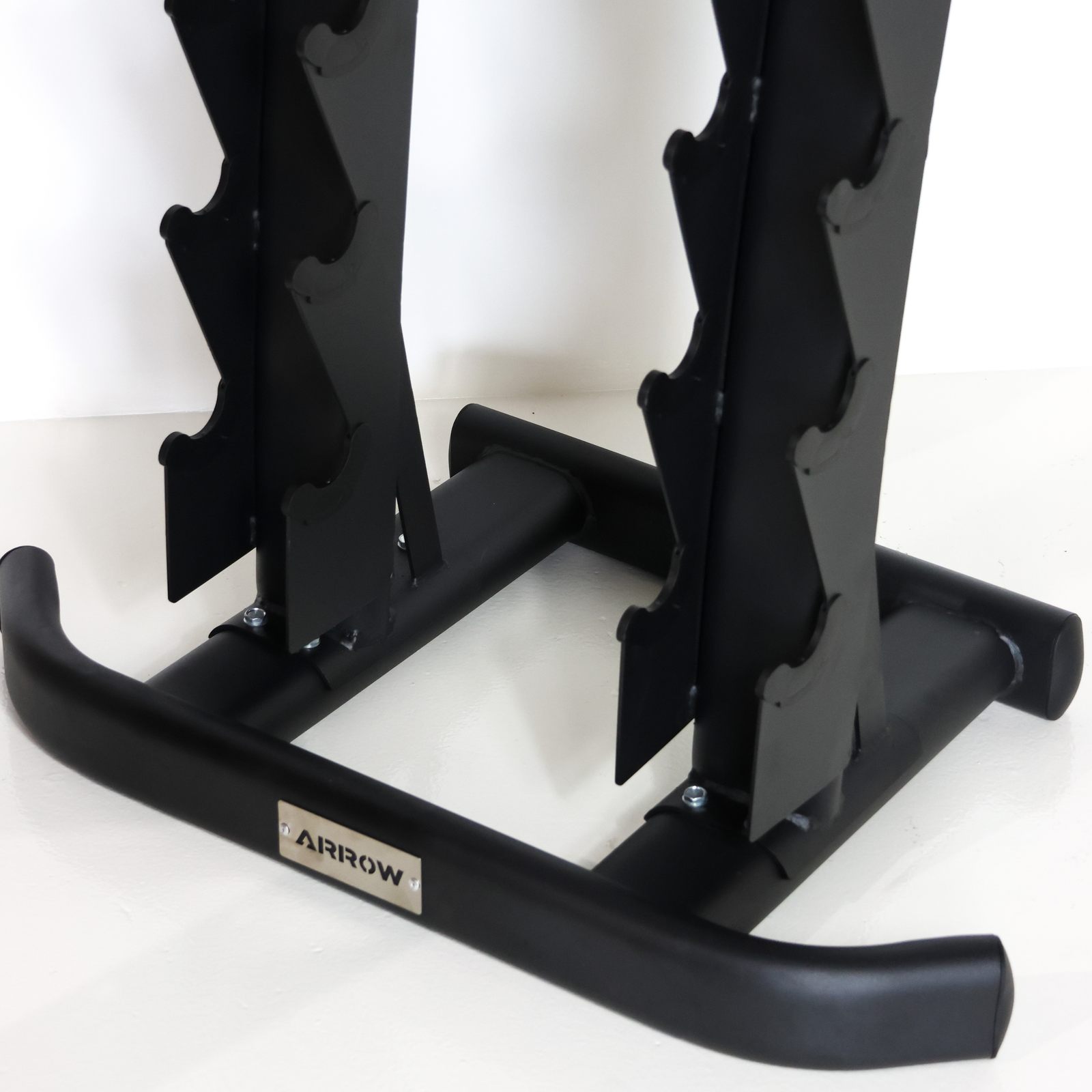 Close-up of a black metal weight rack frame with a small silver ARROW logo plate on the lower bar, photographed against a plain white background.