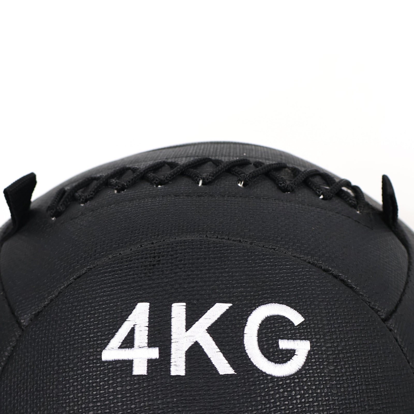 Black medicine ball with '4KG' marking on a white background