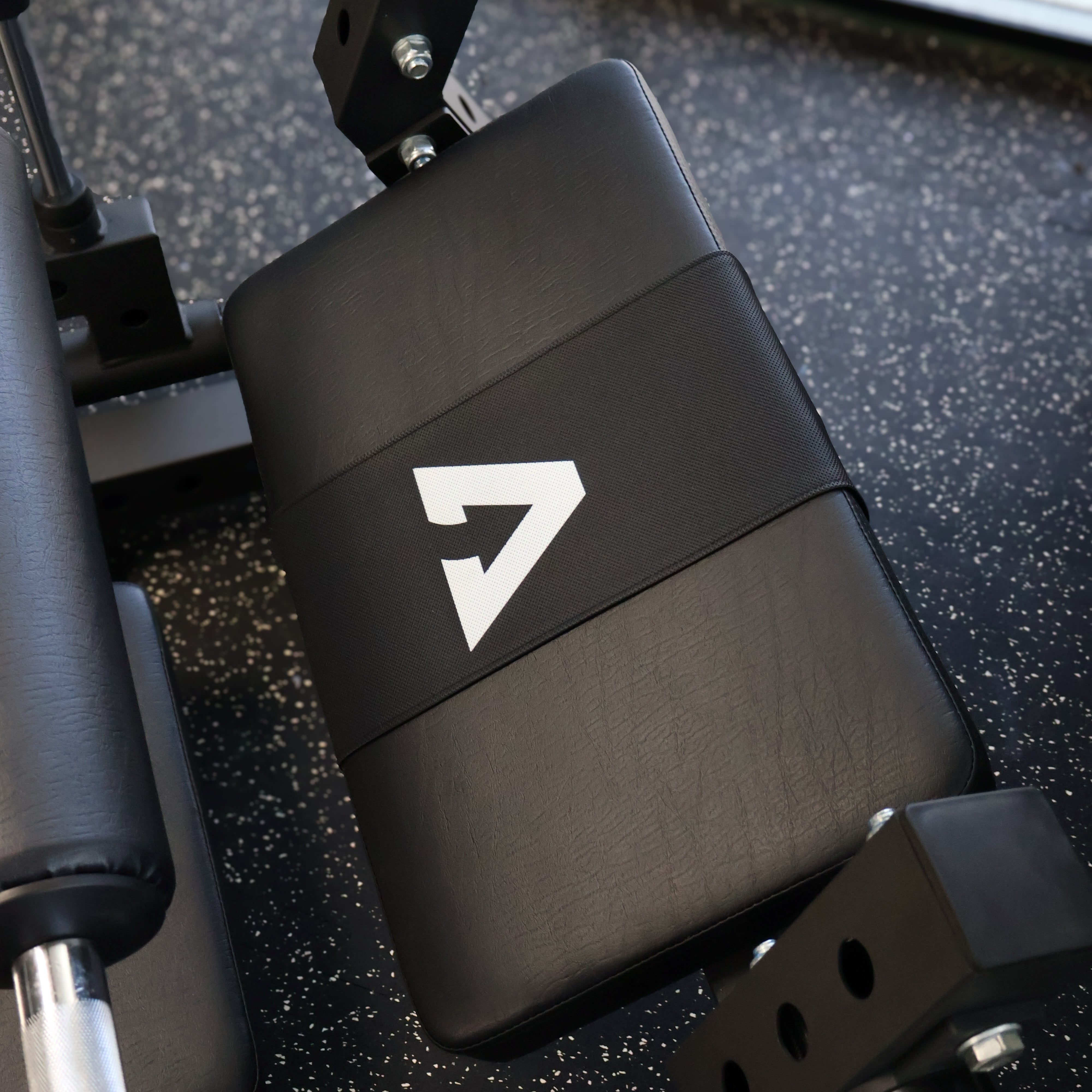 Black weightlifting bench with a logo on a gym floor