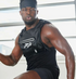 Man wearing a black sleeveless shirt with ATP logo in an indoor setting