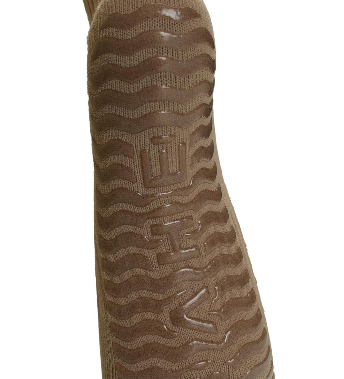 A close-up of a brown sock featuring a wavy tread-like pattern and embossed geometric logo details on a white background.